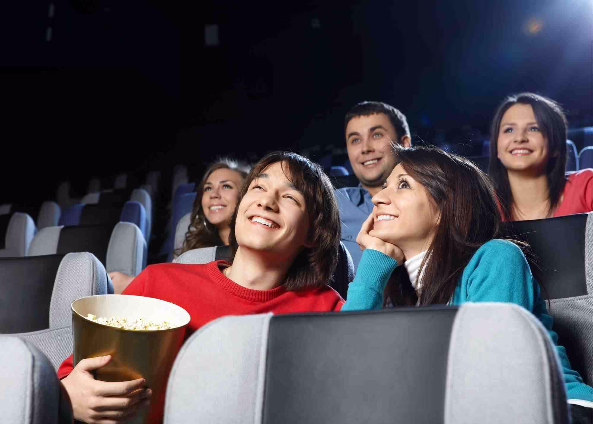 Friends sharing popcorn at a movie.
